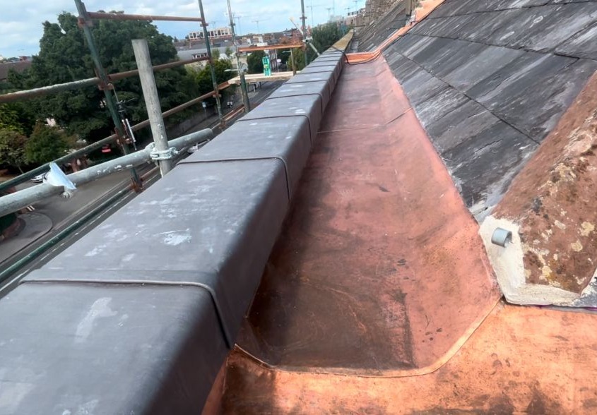 Long copper box gutter between slate roof slopes