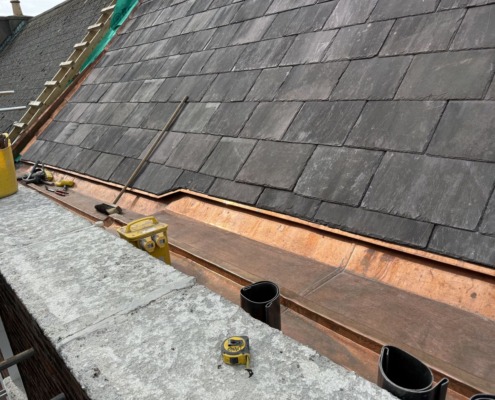 Copper eaves carrier detail at the edge of a slate roof